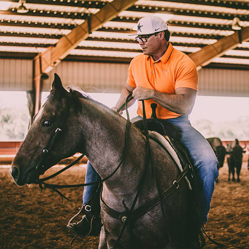Reagan Lancaster riding a cutting horse in the Lancaster Ranch arena — NCHA competitor, Texas cowboy